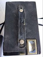Top view of Kodak Six-20 Brownie Plus camera showing leather strap with brand name and rectangular viewfinder.