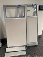 Two cubicle panels shown leaning upright against a wall, with two base panels in front on the floor.