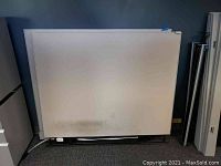 Front view of a large white cubical panel with some dirt marks