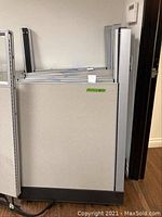 Front view of cubicle partition stacked upright with similar panels in background.