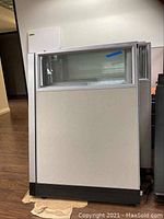 Front and side view of a metal and fabric office cubicle partition panel with a glass window on upper half.