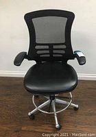 Front view showing mesh backrest, cushioned seat and armrests.