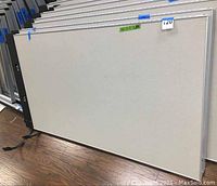 Front view of one office cubicle partition panel, showing light grey fabric surface and metal frame