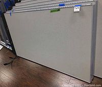 Photo of one fabric-covered cubicle partition panel standing upright showing size and color detail.