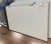 Two beige office partition panels stacked upright on floor.