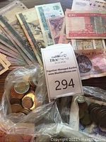 Spread of mixed banknotes on wooden surface including Chinese, Polish and Canadian notes