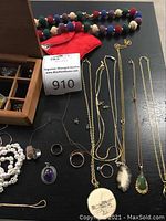 Overview of necklaces, rings and earrings on black surface