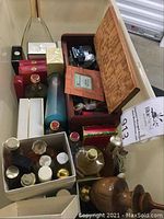 Overall lot view showing multiple boxed and loose fragrance bottles in plastic bin