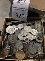 Box of mixed silver half dollars and quarters viewed from above