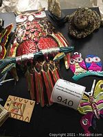 Colorful large metal owl wall hanging with other metal small owl figures and metal butterfly along with a wooden textured carving
