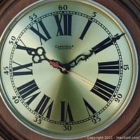 Close-up of clock face showing Roman numerals, ornate black hands, red second hand, and Caravelle branding with 'transistorized' label