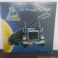 Front cover of Def Leppard's album 'On Through The Night' showing truck and moon artwork.
