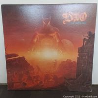 Front cover of Dio "The Last in Line" album showing detailed artwork with a large devil horned figure and fiery orange and red tones.