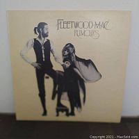 Front cover of the Fleetwood Mac Rumours album showing two band members with stylized black-and-white photo on cream background.