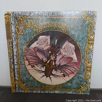 Front cover of Jon Anderson Olias of Sunhillow LP album featuring an intricate dragon illustration and gold border detailing.