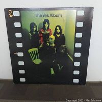 Front cover of The Yes Album vinyl record LP showing band members and greenish-yellow background with film strip border.