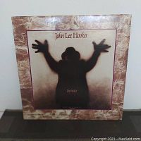 Front cover of John Lee Hooker's The Healer album showing silhouette art and marbled background.