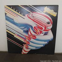 Front cover of Judas Priest Turbo album showing the futuristic robotic hands artwork with the band logo and album title.