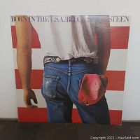 Front cover of Bruce Springsteen's 'Born in the U.S.A.' vinyl album showing a man in jeans with a red cap in the back pocket.