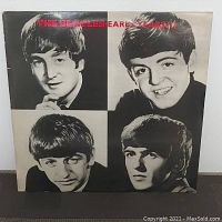 Front cover vinyl album sleeve showing black and white portraits of The Beatles members with red album title text.