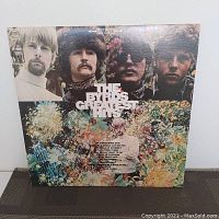 Front cover of The Byrds Greatest Hits album with band photo and psychedelic floral artwork.
