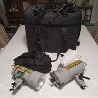 Two Crown VS-201 and VS-202 studio strobes with umbrellas and carrying case on table.