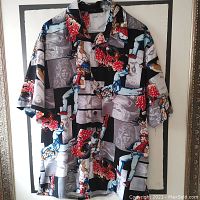 Front view of short-sleeve button-up shirt with anime-style graphics, showing collar and front buttons.