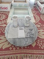 Round marble lazy Susan with salt and pepper shakers and two square marble coasters arranged on top, displayed on patterned rug.