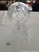 Front and top view of the lead crystal table lamp showing the intricate cut design on the glass globe shade and clear glass base with electric cord attached.