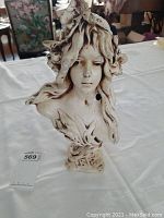 Front view of resin bust showing face and hair with leaf accents