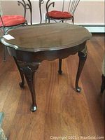 Full view of Ethan Allen side table showing scrolled top rim and cabriole legs.