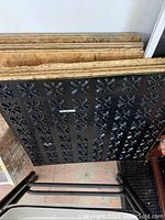 Image showing stacked dry-core garage tiles with black folding chair and a framed painting leaning against the wall.