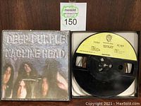 Photo of original Machine Head album cover on reel to reel tape box alongside reel with Warner Bros. yellow label.