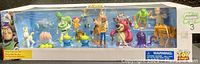 Photo of the Toy Story mega figurine set inside original sealed box with clear plastic window showing 20 colorful figures inside arranged in one row.