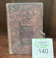 Front view of antique book 'Caxton Edition' with embossed cover and ornate design, shows wear and text on cover.