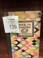 Front view of antique book with colorful geometric cover and title details.