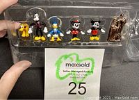 Photo of 6 Disney micro mini figures in original clear plastic packaging: Pluto, Goofy, Donald Duck, Minnie Mouse, Mickey Mouse, and rose-gold Walt Disney and Mickey Mouse on podium.