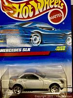 Close-up photo showing a silver Hot Wheels Mercedes SLK die-cast car in original packaging with Hot Wheels and Mattel logos and collector number #1095.
