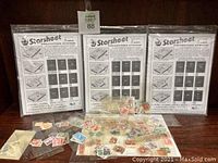 Three packs of Starsheet Collecting Sheets standing upright with loose stamps scattered in front