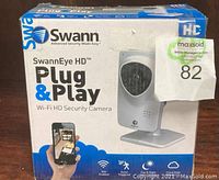 Box of SwannEye HD Plug & Play Wi-Fi HD Security Camera showing front and sides with branding and key features such as Wi-Fi enabled, event triggered, day & night video capability, and cloud edge storage.