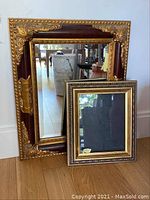 View of full wall mirror with ornate antique gold tone corners and smaller 11x14 picture frame in front