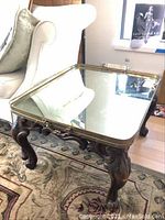 Square vintage table with claw foot wooden base and mirrored top in brass tray frame, viewed at an angle showing missing handle