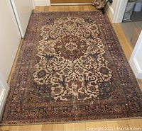 Full view of Sergio Collection area rug showing intricate floral pattern and visible wear across the surface.