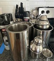 Photo showing three large stainless steel canisters, two stainless steel shakers, and a can of Weiman stainless steel cleaner on kitchen counter.
