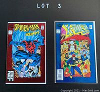 Photo showing two Marvel comic books, Spider-Man 2099 #1 and X-Men 2099 #1, bagged and boarded on a black background with 'LOT 3' written above.