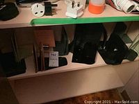 Shelving with multiple black metal bookends and some wooden-accented bookends visible, arranged in groups on shelf.