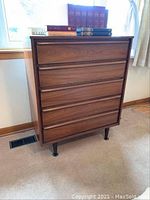 Front view of dresser showing five drawers and legs
