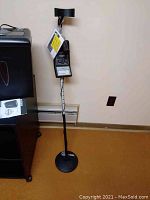 Full view of the metal detector standing upright with visible search coil and control unit.