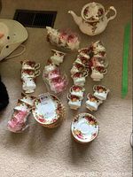 Overhead view of porcelain teapot, demitasse and teacup sets on carpet