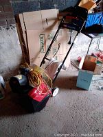 Full view of Toro Power Curve snow thrower showing red and black body, steel handle, wheels, and extension cord.